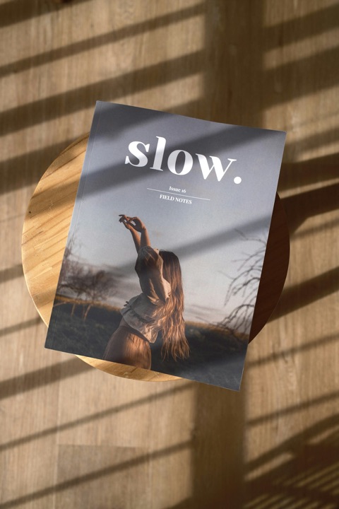 Magazine « slow. » posé sur une table en bois, ombres de fin de journée